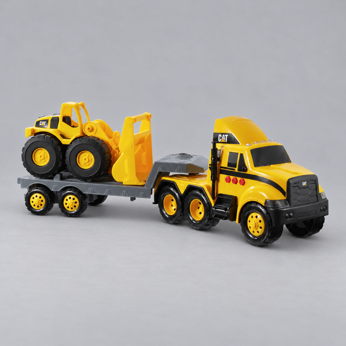 Cat® Heavy Movers semi truck with flatbed trailer carrying a Cat® wheel loader