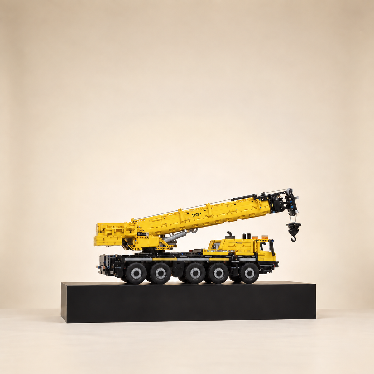 Mould King 17073 5-axle mobile crane building set, yellow — built model on display base, telescopic boom raised