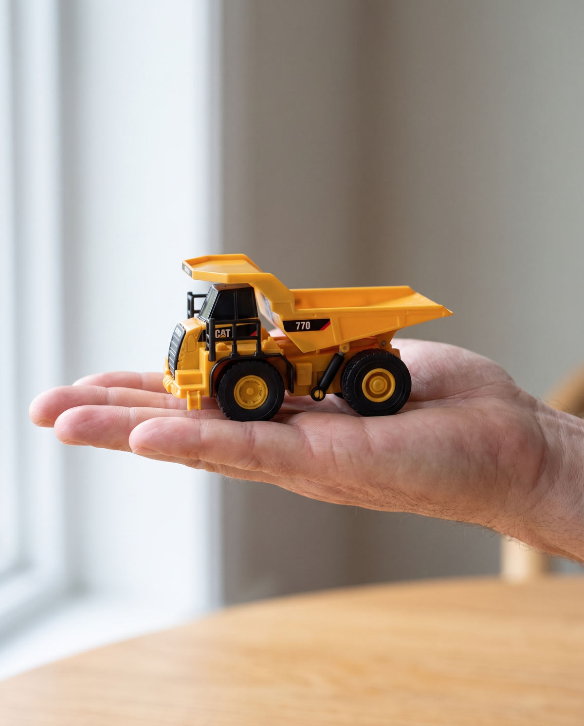 Mini CAT 770 mining truck 1:64 RC — pocket-size model held in the palm of a hand