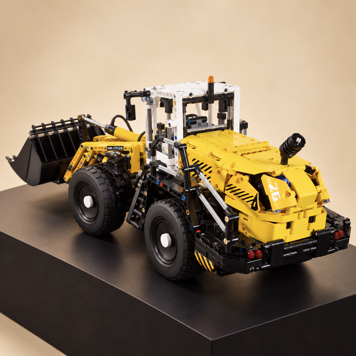 Mould King 17026 RC pneumatic wheel loader building set — built model on display base, front three-quarter view, bucket lowered