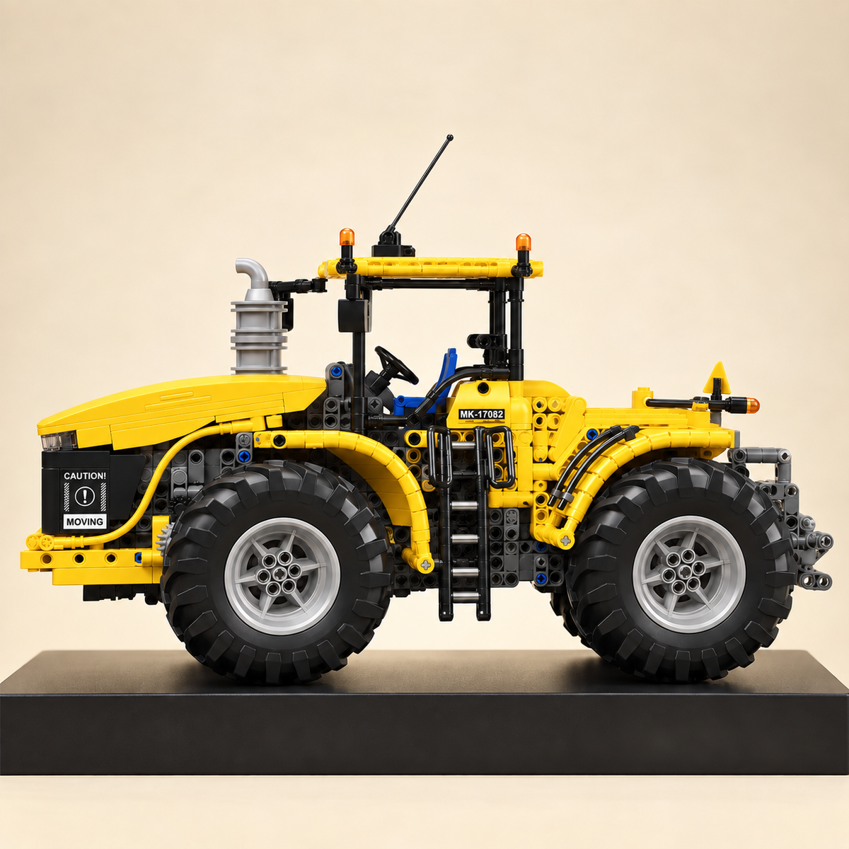 Mould King 17081 articulated 4x4 tractor building set, yellow — built model on display base, side view